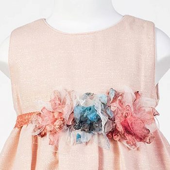Detalle de floral y del tejido del vestido abullonado lamé en tono rosa.