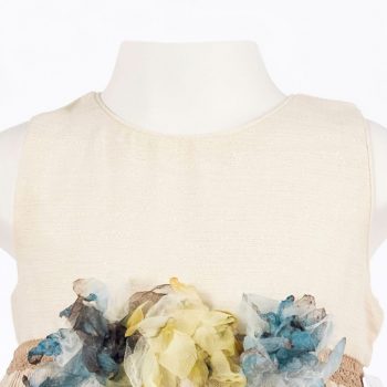 Detalle de floral y del tejido del vestido abullonado lamé en tono beig.