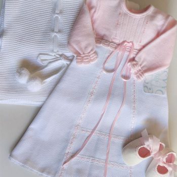 Outfit compuesto por toquilla, faldón y zapatitos en tonos blanco y rosa.