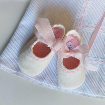 Outfit de bebé niña detalle de los zapatitos en beige y rosa.