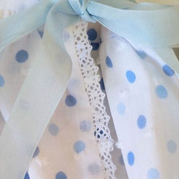 Detalle de conjunto bebé de dos piezas en plumeti de topos azules